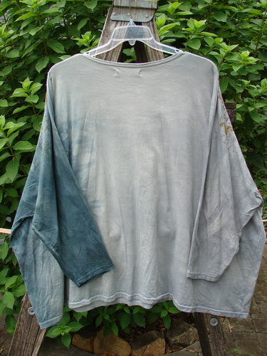 Barclay Dolman Sleeved Big Square Tunic Primitive Path Mottled Teal Gray OSFA displayed on a clothes rack, showcasing its unique, flowing silhouette and long sleeves, embodying BlueFishFinder's vintage, expressive style.