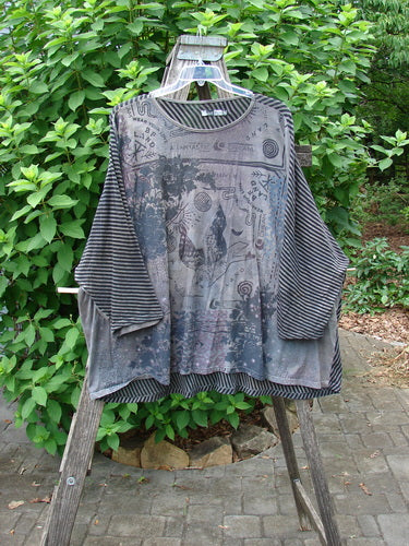 Barclay Modernist High Low Top Fantastic Dream Black Grey Stripe OSFA displayed on a clothes rack, showcasing its unique high-low hem and stripe pattern, emphasizing creative design and individuality.