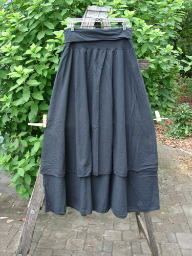Close-up of the Barclay NWT Batiste Fold Over Stardust Two Tier Skirt Unpainted Black Raven Size 0, elegantly displayed on a wooden stand, highlighting its intricate two-tier design and vintage Blue Fish aesthetic.
