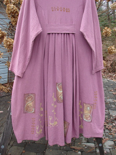 1996 Reprocessed Equinox Coat in Petunia, size 2. A pink dress with a pattern on it. Features include a double stacked vintage button line, widening lower bell shape, tabbed and gathered rear pleats, and deep side pockets.