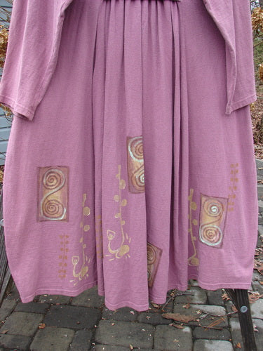 1996 Reprocessed Equinox Coat in Petunia, a purple dress with gold designs. Features include vintage buttons, bell shape, rear pleats, S curve seams, deep side pockets, and an uptown collar. Made from desirable textured cotton.