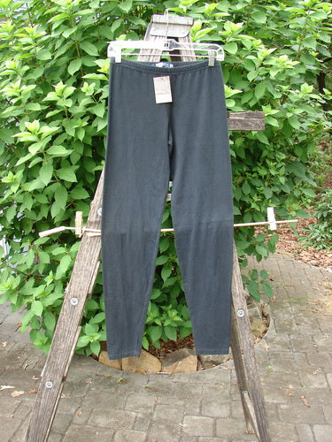 Barclay NWT Cotton Lycra Lightweight Legging Unpainted Black Size 0 displayed on a wooden ladder, showcasing its sleek design and flexible fabric, ideal for expressing individuality through vintage-inspired fashion.