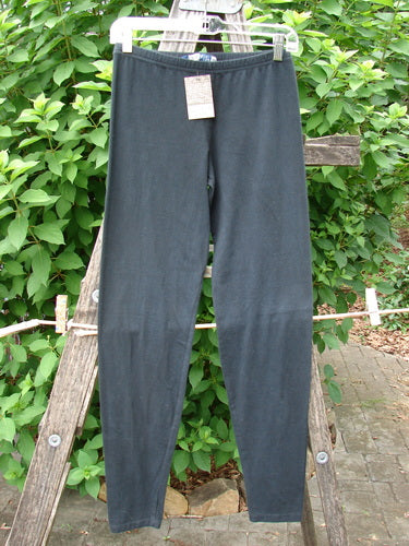 Barclay NWT Cotton Lycra Lightweight Legging Unpainted Black Size 0 draped elegantly on a wooden ladder, showcasing its sleek design and stretch fabric, ideal for versatile, everyday wear.