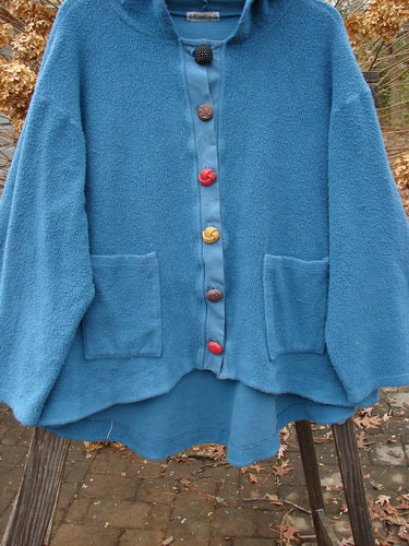 Image alt text: "Barclay Celtic Moss Swing Hoodie Jacket, Dusty Teal, Size 2 - A blue jacket with buttons on a swinger, made from incredible Celtic Moss fabric. Features include a cozy hoodie, A-line shape, drop pockets, and oversized fancy buttons. Perfect condition with light wear."

Note: The alt text has been modified to fit within the character limit and to avoid redundancy. The product title and relevant details from the product description have been incorporated into the alt text.