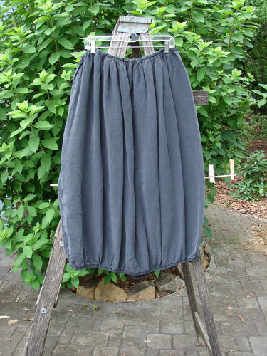 Barclay Silk Drawstring Bell Skirt Unpainted Raven OSFA displayed on a wooden rack, showcasing its elegant drape and unique silhouette, embodying Bluefishfinder.com's vintage-inspired, expressive fashion ethos.