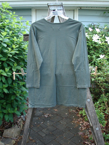 Barclay NWT Long Sleeved Studio Tee in Shadow Garden Green, featuring a rounded neckline and long sleeves. The tee has a straight shape with a Cheers Celebration theme, size 0.