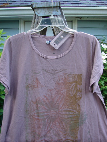 Barclay NWT Cap Sleeved Travel Tee, Size 0, features a rounded neckline, wide cap sleeves, and an A-line shape with a varying hemline, adorned with a subtle single flower theme.