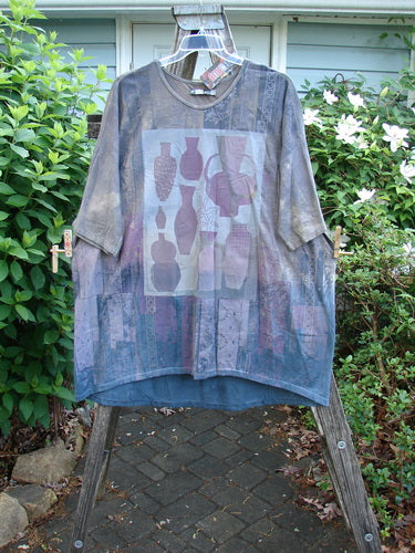 Barclay NWT Tournesol Tunic Fancy Vase Lunar Eclipse OSFA features a tunic-length design with drop shoulders, loose three-quarter sleeves, and a rounded neckline, showcasing a unique fancy vase theme.