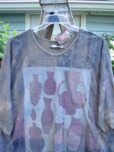 Barclay NWT Tournesol Tunic Fancy Vase Lunar Eclipse OSFA features a mid-length, loose-fit design with drop shoulders, three-quarter sleeves, rounded neckline, and varying hemline, showcasing a fancy vase motif.