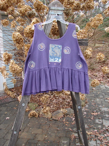 1992 Peplum Top Spinner Deep Violet OSFA: A purple shirt with a wide waist, yoked waist seam, and gathered bottom flounce.