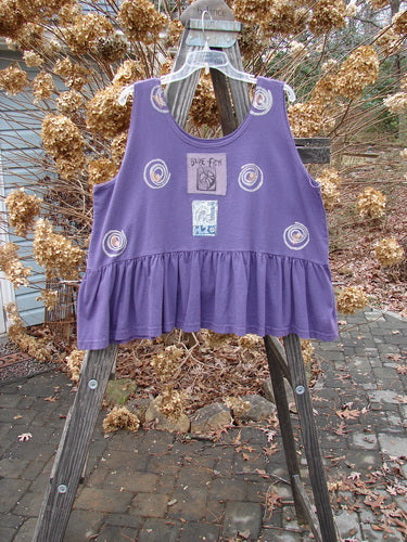 1992 Peplum Top Spinner Deep Violet OSFA: A rare, vintage flounce top in deep violet. Features a yoked waist seam, rounded neckline, and wide waist measurement. Signature Blue Fish patch and gathered bottom flounce. Bust 50, Waist 54, Hem Circumference 100, Length 25.
