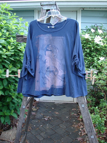 The Barclay NWT Draw Gather Sleeve Cafe Top features a rounded neckline, swinging A-line shape, and cozy wide sleeves with rolled edges, embodying the Night Flight theme in a distinctive design.