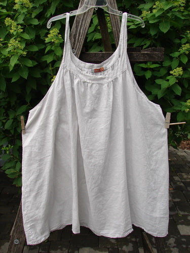 Barclay Batiste Banded Collar Slip Dress Unpainted Natural Size 1 hangs on a hanger outdoors, showcasing its gathered yoke, deep neckline, and swingy silhouette, epitomizing BlueFishFinder's vintage-inspired, expressive style.