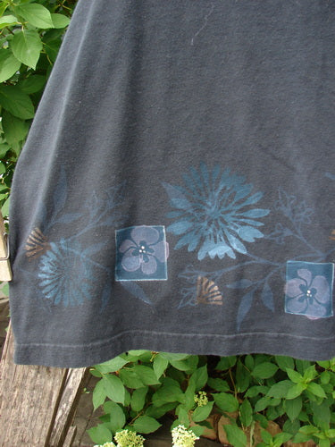 Barclay Cotton Lycra Tank Border Garden Black Size 2, featuring a dark base with a decorative blue and teal floral border along the hem, hanging outdoors, capturing vintage aesthetic and individuality.