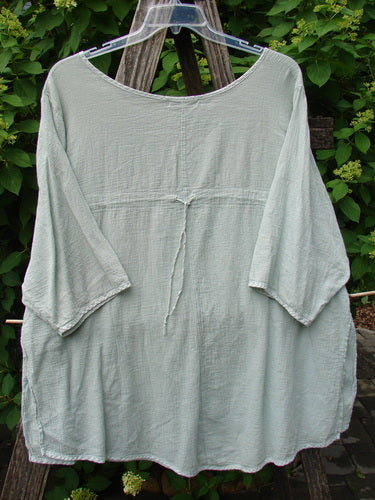 Barclay Gauze Round Bottom Tie Back Pocket Top Unpainted Grass Size 2 displayed on a hanger, showcasing its loose, flowing design and three-quarter sleeves, capturing the vintage essence of Bluefishfinder.com.