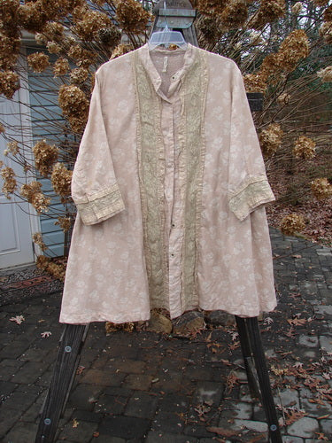 A Magnolia Pearl European Cotton Snap A Line Cardigan with floral mix pattern, featuring an oversized front snap line, tiny cuff snaps, stacked lace layers, and lacy lower cuffs.
