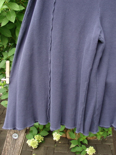 Barclay Thermal Fold Over Crop Pant Unpainted Deep Violet Size 1 clipped to a clothesline, showcasing a ribbed knit texture, with lush foliage and brick surface subtly framing this vintage-inspired Blue Fish Clothing piece.