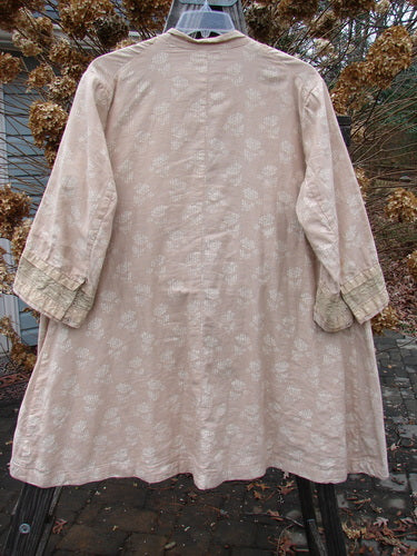 A close-up of the Magnolia Pearl European Cotton Snap A Line Cardigan, featuring an oversized front snap line, tiny cuff snaps, and layers of vertical stacked lace. The cardigan has a lovely floral mix print interior and exterior, and slightly longer than three-quarter length sleeves. Perfect for expressing your individuality.