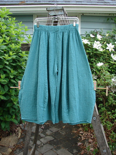 Barclay NWT Pucker Crop Mojo Pant in Jade features a unique 3D diamond cut from knee down, exterior flop front pockets, and a full elastic waistband, embodying BlueFishFinder's creative vintage style.
