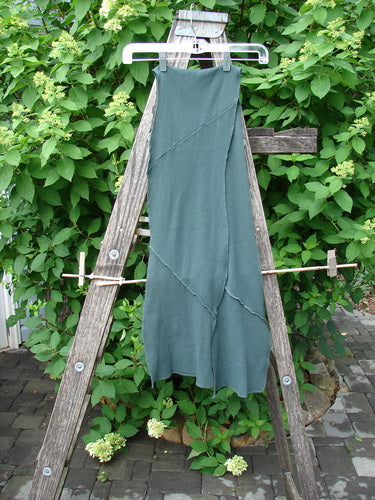 Barclay Thermal Patched Curvy Scarf Army Forest OSFA hangs gracefully on a rustic wooden trellis, showcasing its waffle texture and sweet curly edges, surrounded by lush greenery.