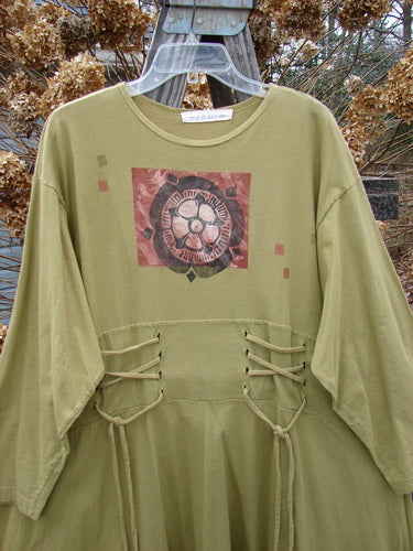 1997 Caryatid Dress with green shirt design, logo, and knot accents. Made from organic cotton. Versatile size and dimension with adjustable laces. A vintage piece from BlueFishFinder's Fall Collection.