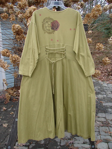 1997 Caryatid Dress, size 2, in Lantern color, made of mid-weight organic cotton. Features long laces in front and back, adjustable for size. A-line lower, drop shoulders, abstract theme paint. Bust 52-60, waist 52-60, hips 62-70. Length: 56 inches.