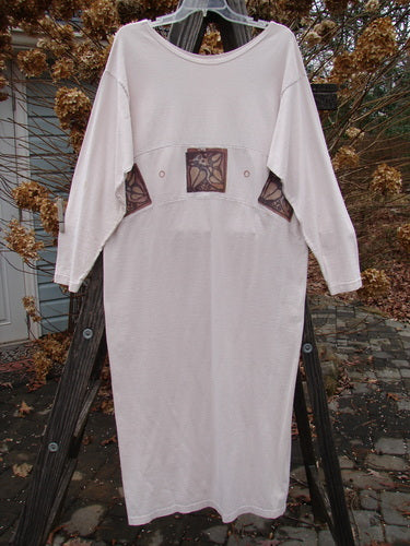 1995 Empire Dress Heart Leaf Champagne Size 1: A white dress on a wooden rack, featuring a curved upper waist panel, rolled neck line, and narrower lower sleeves.
