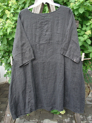 Barclay Linen Sectional Urchin Dress Leaf Black Size 1, displayed on a hanger, features a loose fit, empire waist, scooped neckline, double side pockets, and varying hemline, with visible bleach marks on sleeves.