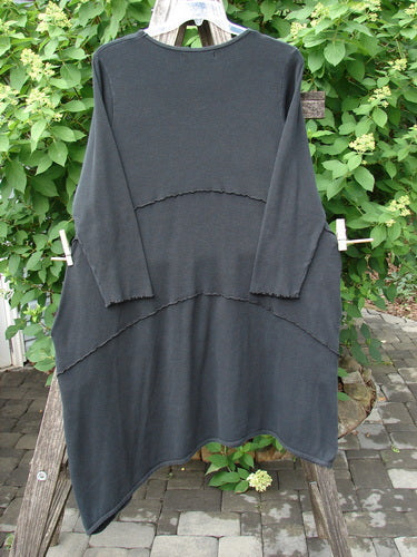 Barclay Thermal Exterior Stitch Three Tier Dress Unpainted Black Size 2 displayed on a wooden ladder, showcasing its scooped neckline and layered look with horizontal raw-edge seams, epitomizing vintage Blue Fish Clothing's creative freedom.