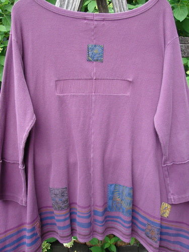 Barclay Patched Thermal Single Button Cardigan Tiny Square Murple Size 1 features a waffle-knit back, patchwork squares, and a flared hem, hanging artistically against a wooden trellis with foliage.