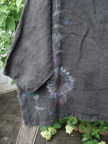 Barclay Linen Lantern Boxy Top Side Floral Black Size 1, displayed outdoors on a wooden bench, features hand-painted botanical motifs with a square boxy shape, drop shoulders, and rounded neckline.