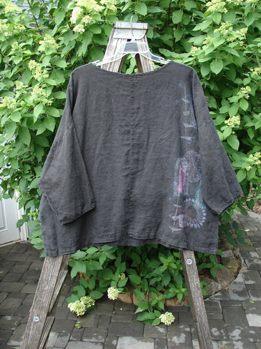 Barclay Linen Lantern Boxy Top Side Floral Black Size 1, featuring a loose fit, three-quarter sleeves, and floral motifs in pale hues. Displayed on a hanger against lush greenery, embodying BlueFishFinder's vintage aesthetic.
