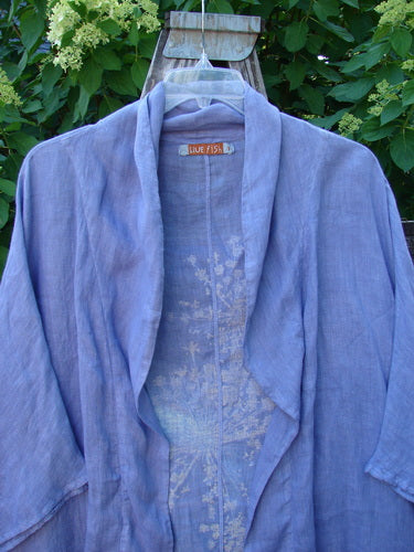 Barclay Linen Open Front Cheerful Cardigan Jacket features sky-blue linen with a draped, open front, shawl collar, and subtle floral embroidery. Hangs on a clear hanger, reflecting Bluefishfinder.com's vintage style.