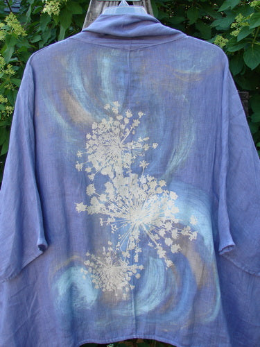 Barclay Linen Open Front Cheerful Cardigan Jacket Rear Starburst Iris Size 1 features a soft lavender kimono-style design with a botanical motif on the back, displayed against lush green foliage.