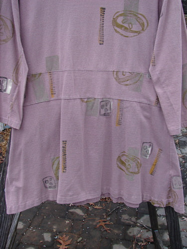 1991 Workshop Dress with Spin Stone print, purple, long-sleeved, tailored fit, drop waistband, pleats, pin tucking, shorter arm lengths, scoop neckline.