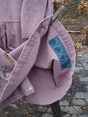 1991 Workshop Dress with Spin Stone design, in Currant color. Close-up of the dress's unique pleats and drop waistband.