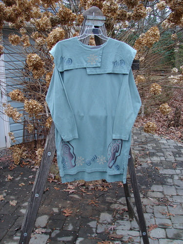 1996 Trifocal Top Celestial Trinket Size 1: A unique blue shirt on a clothes rack, featuring a sectional collar, abstract forest theme paint, and Blue Fish patch.