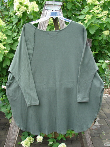 Barclay Thermal Monte Verde Vented Tunic in Army draped on a wooden easel, showcasing its relaxed batwing silhouette, rounded neckline, and slim sleeves, with visible side vents and exterior stitchery.