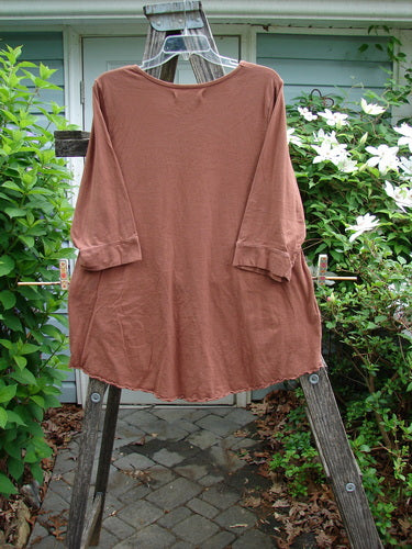 Barclay Banded Artist Pocket Top Sunflower Rust Size 1 features a rounded neckline, A-line shape, double diagonal pockets, three-quarter sleeves with banded cuffs, and a rounded hemline with curly edges.