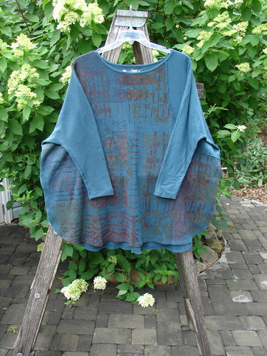 Barclay Thermal Monte Verde Vented Tunic Grid Blend Tealen OSFA displayed on a hanger, showcasing its loose fit, rounded neckline, side vents, and exterior stitchery against an outdoor background.