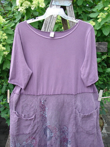Barclay Linen Cotton Two Pocket Tie Back Square Dress Bloom Burst Plum Size 1, featuring a lavender knit top with elbow-length sleeves and a floral print lower half with front patch pockets.