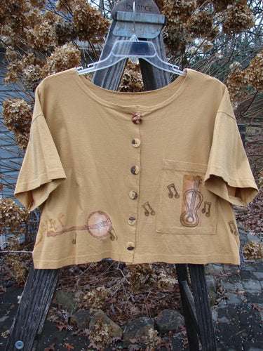 1994 Song Top Make Music Dijon Size 2: Wide crop box shape tan shirt with notes, oversized buttons, and front pocket.