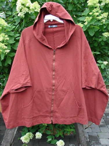 Barclay PMU Patched Hooded Postcard Zipper Jacket Vest features a full front zipper, drop shoulders, roomy kangaroo pockets, and a graphic rear patch, displayed outdoors against foliage.