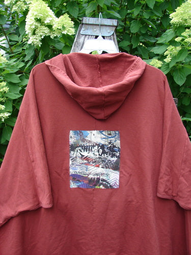 Barclay PMU Patched Hooded Postcard Zipper Jacket Vest displayed on a hanger, featuring a unique abstract rear patch design, generous hood, and dolman shoulders, embodying Bluefishfinder.com's vintage, expressive style.