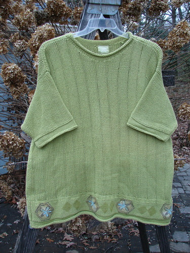 1999 Spring Pullover Tunic Sweater Kiwi Size 2: A green sweater with varied textures and knits, featuring an A-line shape, drop shoulders, and rolled neck sleeves and hemline.