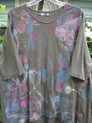 Barclay Tournesol Tunic Seed Pod Garden Stick OSFA features a tunic-length with drop shoulders, three-quarter sleeves, a rounded neckline, and a varying hemline, showcasing a floral garden theme on organic cotton.