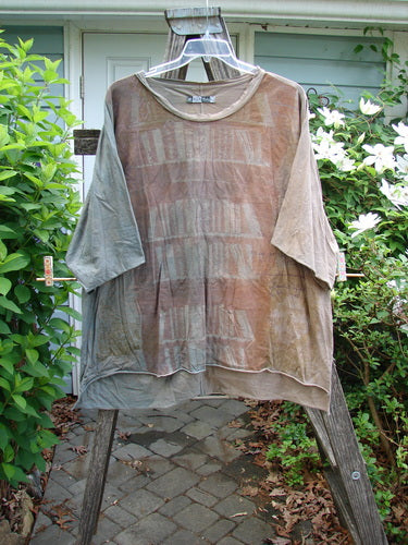 Barclay Raw Edge Flutter Collar High Low Top Library Mottled Latte OSFA, showcasing a wide boxy shape, rounded flutter neckline, short dolman sleeves, and a raw-edged hi-low hemline.