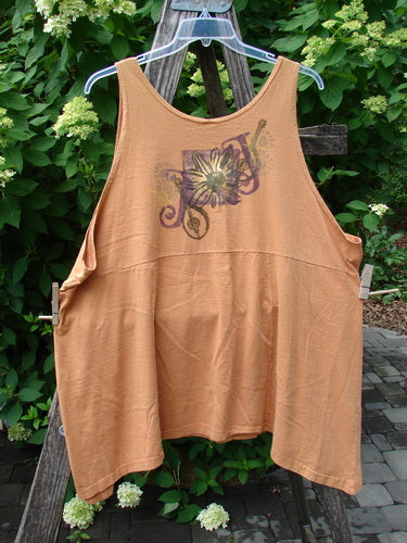 1994 Short Simple Smock Double Daisy Oro Size 1: An orange, loose-fitting sleeveless top with a stylized floral graphic, displayed over a wooden ladder, showcasing its flowing design and rounded neckline.
