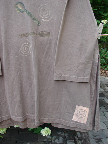 1999 Silverware Top Reverse Dining Riverbed OSFA featuring a stamped spoon and fork graphic with spiral motifs, pencil pockets, and a steaming coffee cup patch, draped outdoors over a bench or clothesline.