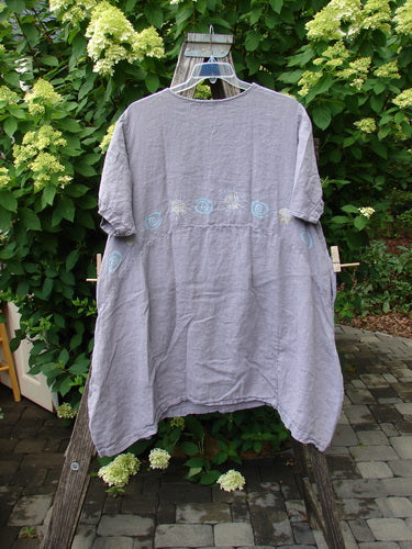 1997 Urchin Dress Sun Ray Swirl Sea Urchin Size 2, featuring hand-stitched embroidery and a paneled hemline, displayed on a rustic frame against lush foliage, epitomizes Bluefishfinder's vintage, artistic style.